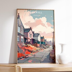 May include: A framed art print featuring a colorful illustration of Kirkwall, Scotland. The artwork depicts a row of houses along a street, with the text "KIRKWALL Scotland" at the top. The color palette includes pinks, blues, and greens.