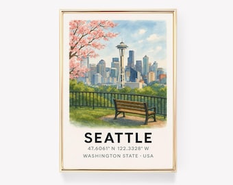 May include: Watercolor print of Seattle, Washington, featuring the Space Needle, cityscape, and a park bench. The image includes a cherry blossom tree and the city's name with coordinates. The artwork is framed in a gold-colored frame.