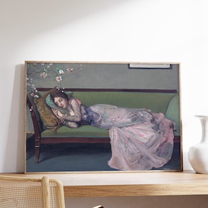 May include: A framed painting of a woman in a pink gown lying on a green couch. The woman is asleep with her head resting on a pillow. There are pink flowers in the background.