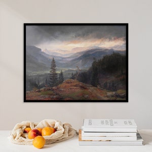 May include: A framed landscape painting depicting a mountain range with a valley in the foreground. The sky is a dark gray with a hint of orange in the distance. The mountains are covered in trees and the valley is green.