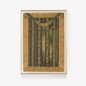 May include: A framed piece of fabric with a green and gold pattern. The fabric is mounted on a beige background and has a small tag with text on it.