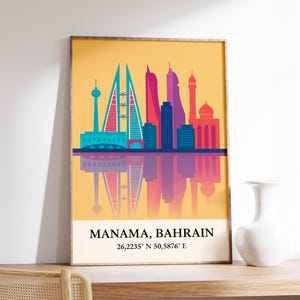 May include: A framed art print featuring a colorful skyline of Manama, Bahrain, with a mirrored reflection. The print has a yellow background and includes the city's name and coordinates.