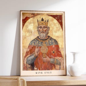 May include: A vintage-style illustration of King Cnut, a historical figure, depicted in a red and blue robe with a gold crown and holding a golden orb. The image is set against a gold background with a halo around the king's head. The text "KING CNUT" is printed below the image.