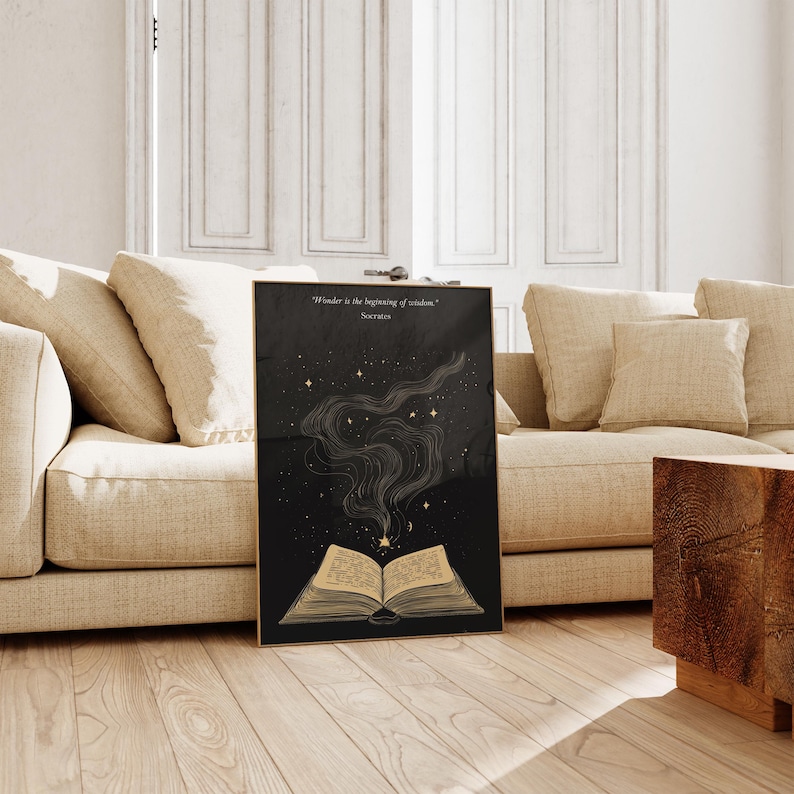 May include: A black and gold print with a quote by Socrates, "Wonder is the beginning of wisdom." The print features a stylized open book with a golden glow and stars in the background.