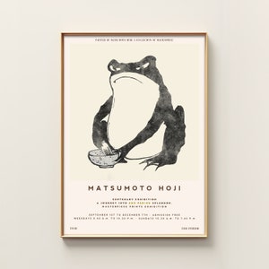 Könnte beinhalten: Eine Schwarzweißillustration eines Frosches, der eine Schüssel und einen Schneebesen hält. Das Bild ist ein Plakat für eine hundertjährige Ausstellung von Edo-Perioden-Drucken von Matsumoto Hoji. Der Text auf dem Plakat lautet: "Gemalt von Matsumoto Hoji, Eine Sammlung von Meisterwerken, Hundertjährige Ausstellung, Eine Reise in die Pracht der Edo-Periode, Ausstellung von Meisterwerken, 1. September bis 7. Dezember, Eintritt frei, Wochentage 9:45 Uhr bis 22:30 Uhr, Sonntage 10:30 Uhr bis 19:45 Uhr, Kröte, Edo-Periode."