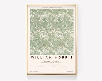 May include: A framed art print featuring a green floral pattern on a cream background. The print is labeled "William Morris" with text about a cotton prints exhibition. The frame is gold.
