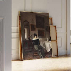 May include: A painting of a woman in a dark dress sitting at a table in a room with several framed pictures on the wall.