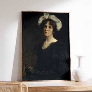 May include: A framed oil painting of a woman wearing a white lace hat and a black dress. The woman is looking directly at the viewer. The painting is set against a dark background.