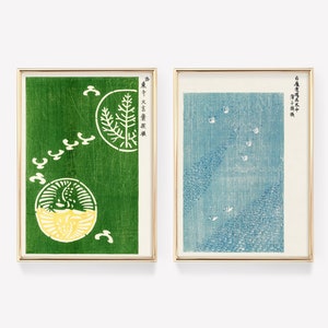 Puede incluir: Dos impresiones enmarcadas con texto japonés y diseños abstractos. La impresión de la izquierda tiene un fondo verde con un diseño amarillo y verde. La impresión de la derecha tiene un fondo azul con un diseño blanco.