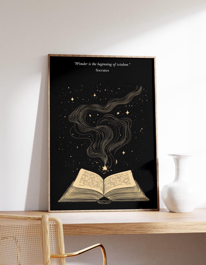 May include: A black and gold print with an open book with stars and a quote by Socrates that reads "Wonder is the beginning of wisdom."