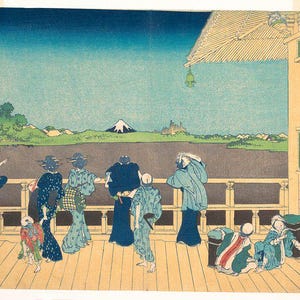 May include: A woodblock print depicting a group of people on a balcony overlooking a landscape with Mount Fuji in the distance. The print is in shades of blue, green, and brown. The text on the print reads "雪舟筆 富士", which translates to "Snow Boat Brush, Mount Fuji".