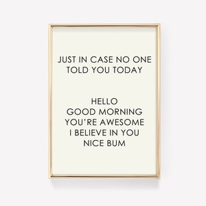 Op de afbeelding: Een ingelijst afdruk met een witte achtergrond en zwarte tekst die luidt: "Just in case no one told you today, Hello, Good morning, You're awesome, I believe in you, Nice bum."