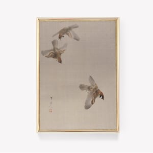 May include: A framed painting depicting three sparrows in flight against a light beige background. The sparrows are brown and white with dark eyes. The painting is signed in the bottom right corner.