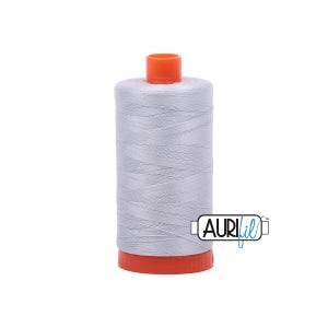 May include: A spool of light gray thread with an orange top and bottom. The thread is tightly wound around a cylindrical core. The brand name "AURIfil" is visible on the side of the spool.