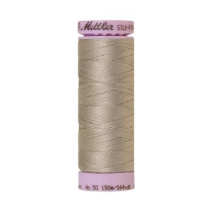May include: A spool of beige thread with a pink label that reads "Mettler Silk-Finish No. 50 150m/164 yds."