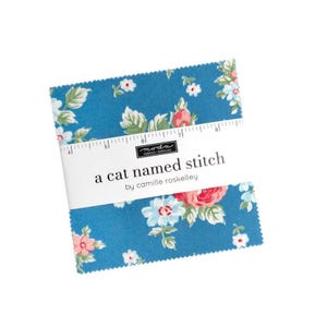 May include: A stack of fabric squares with a floral pattern in shades of blue, pink, and white. The fabric is labeled "a cat named stitch" by Camille Roskelley. A ruler is placed across the top of the fabric squares.