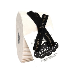 May include: A roll of off-white fabric with a black ribbon tied around it. The ribbon has gold text that reads "Star Society". A white tag with black text and star graphics is attached to the ribbon.