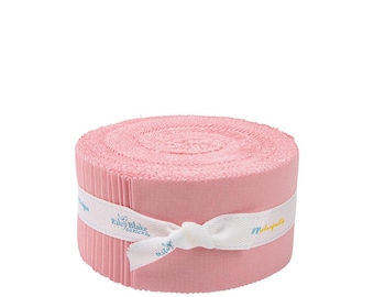 May include: A roll of pink fabric strips, bound with a white ribbon. The ribbon is tied in a bow and features the text "Riley Blake Designs" and "#Perfectly". The fabric is a solid, light pink color.