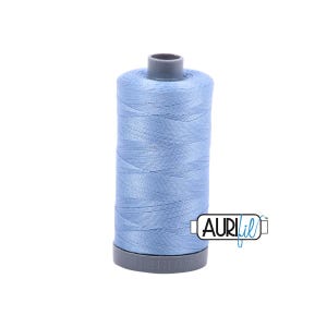 May include: A spool of light blue thread with a gray top and bottom. The thread is tightly wound around the spool. The brand name "AURIfil" is printed on the side of the spool.