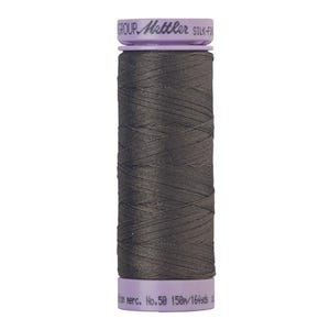 May include: A spool of dark gray thread with a purple label that reads "GROUP. Gütermann SILK-FIX No. 50 150m/164yds"