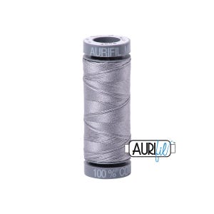 May include: A spool of Aurifil thread in a light gray color. The spool has gray plastic caps with the brand name and thread details. The thread is 100% cotton.