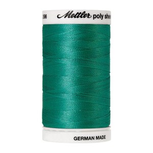 May include: A spool of teal green Mettler poly thread with "Mettler poly sheen" and "GERMAN MADE" printed on the label.