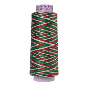 May include: A spool of red, white, and green striped thread. The label reads "Group Mettler SILK-FINISH Cotton mercer. No. 50 150m".