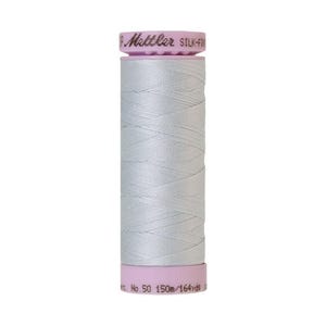 May include: A spool of light gray thread with a pink and brown label that reads "Metzler Silk-Finish No. 50 150m/164yds".