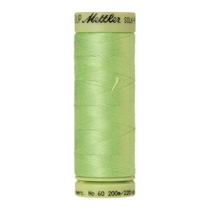 May include: A spool of light green thread with the text "Metzler Silk-Finish" on the label. The spool is labeled "No. 60 200m/220yd".