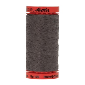 May include: A spool of dark gray thread with a red label that reads "Mettler Group No. 100 500m/547yds".