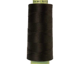Może przedstawiać: Szpulka ciemnobrązowej nici z etykietą "Group Mettler SILK-F Cotton merc. No. 60 300m"