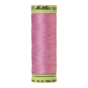 May include: A spool of pink thread with a green label that reads "DUP. Mettler SILK-F merc. No. 60 200m/220yd".