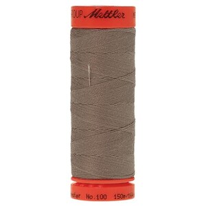 May include: A spool of brown thread with a bright orange label that reads "Mettler Group No. 100 150m/164yd"