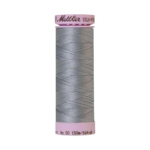 May include: A spool of gray thread with a pink label that reads "Metzler Silk-Finish No. 50 150m/164yds".