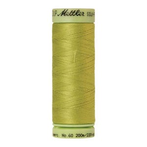May include: A spool of green thread with the text "Mettler Silk-Finish" on the label. The spool is labeled "No. 60 200m/220yd".