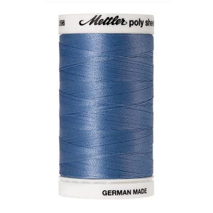 May include: A spool of blue Mettler poly thread with the text "Mettler poly sheen" and "GERMAN MADE" on the label.