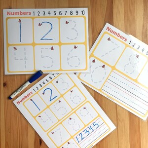 May include: Three worksheets with yellow borders and butterfly graphics for practicing writing numbers 1 through 10. The worksheets have dotted lines to guide the user in tracing the numbers. One worksheet has a section for writing the numbers 1 through 5.