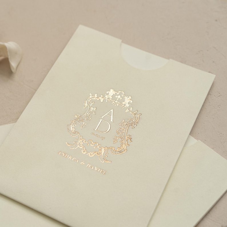 A close-up image of a cream-colored envelope with a gold embossed logo on it.