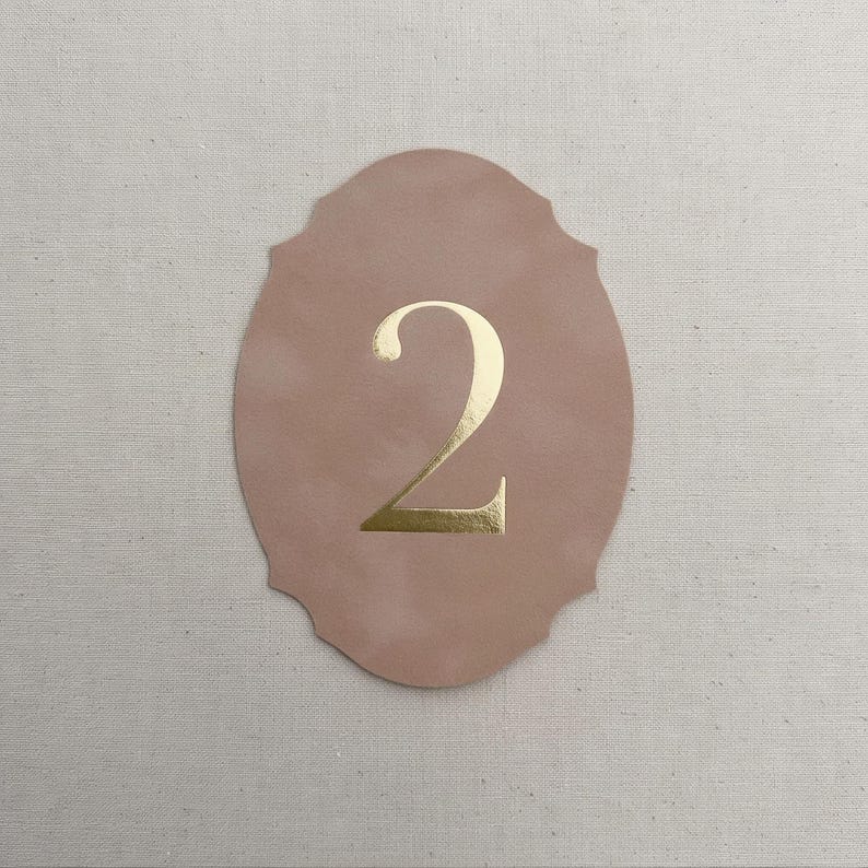 a number 2 on a pink oval background.