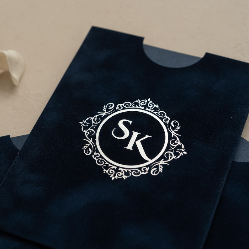 A close-up view of a dark blue fabric with a white circular logo featuring the letters 'SK' in the center.