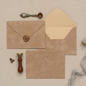 a collection of items related to stationery and office supplies, including an envelope, a wax seal, a stapler, and a ribbon.