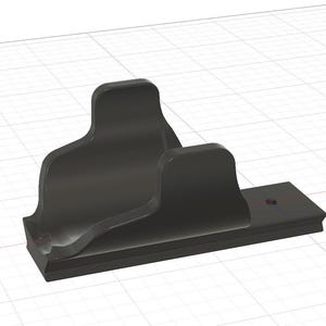 May include: A black, stylized bracket with a curved design. The bracket has a rectangular base with a decorative edge and a vertical support with a curved top. The design is rendered in a 3D style.