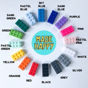 May include: An image with the text "CHOOSE YOUR COLOUR" and "MADE HAPPY". It displays various colorful toy building blocks in shades of green, blue, purple, pink, yellow, orange, red, black, grey, white, and silver. Each block is labeled with its color.