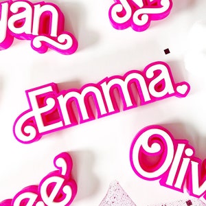 Peut inclure: Lettres en plastique 3D roses orthographiant les noms "Olivia", "Emma", "Jan", "Marie" et "Thee".