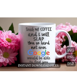 May include: White ceramic coffee mug with black text that reads "touch my coffee and I will SLAP you so hard not even Google would be able to find you." The Google logo is in the middle of the text. Pink flowers are in the background.