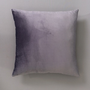 May include: A soft, plush pillow with a gradient design, transitioning from a dark purple to a light gray.