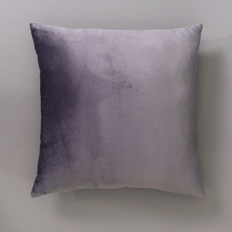 May include: A soft, plush pillow with a gradient design, transitioning from a dark purple to a light gray.