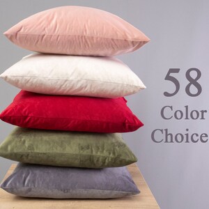 May include: A stack of five decorative throw pillows in various colours, including pink, white, red, green, and grey. The text "58 Colour Choices" is visible in the image.
