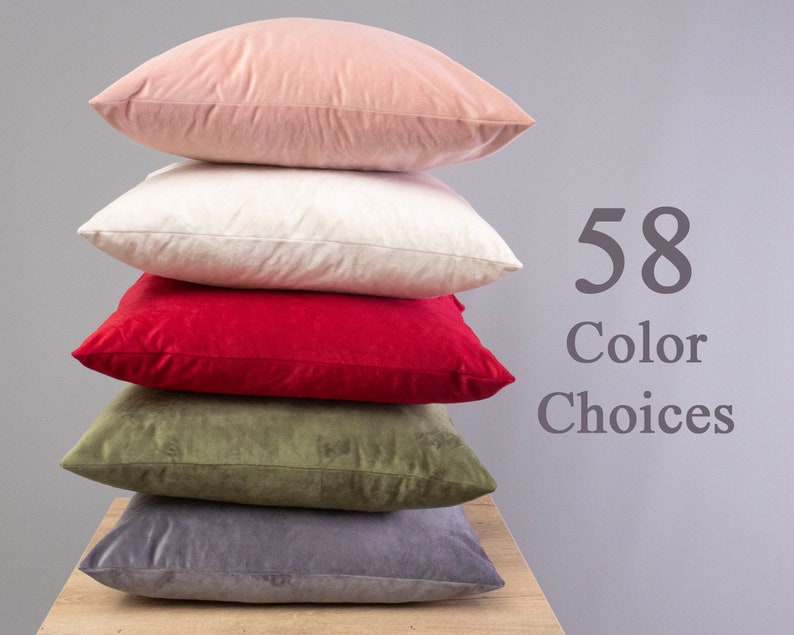 May include: A stack of five decorative throw pillows in various colours, including pink, white, red, green, and grey. The text "58 Colour Choices" is visible in the image.