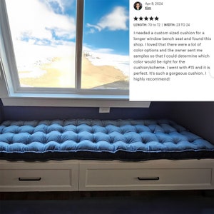 May include: A blue window seat cushion with button tufting. The cushion is 178 to 183 cm long and 58 to 61 cm wide. The cushion is sitting on a white window seat with two drawers.